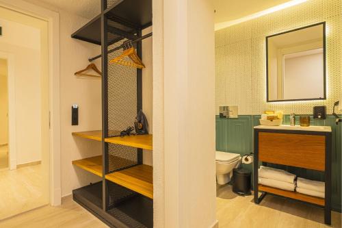 a bathroom with a sink and a toilet in a room at Lyse Jülide Hotel in Çeşme