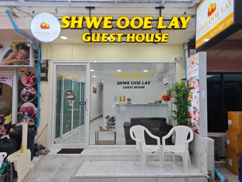 a store with two white chairs outside of a guest house at Shwe Ooe Lay Guest House in Bangkok
