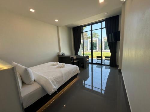 a bedroom with a bed and a desk and a window at Pearlix Koh Mook in Ko Mook