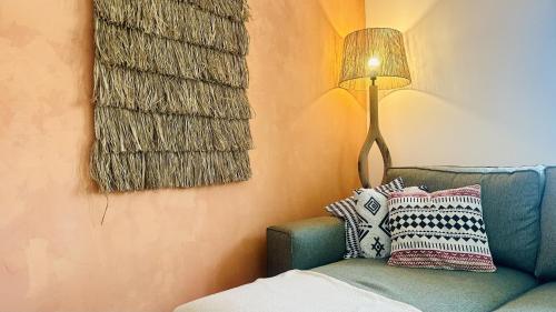 a living room with a blue couch and a lamp at La Casita Nazaré - private pool in Nazaré