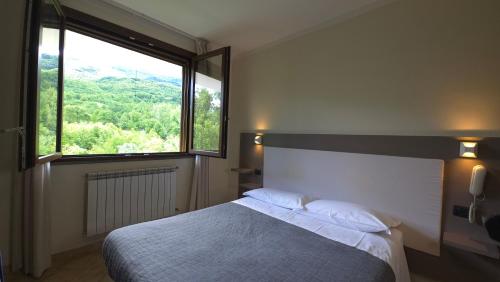 a bedroom with a bed and a large window at Albergo Lago Verde in Pennabilli