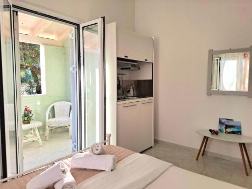 a room with a bed and a table and a kitchen at Alegria apartments in Gaios