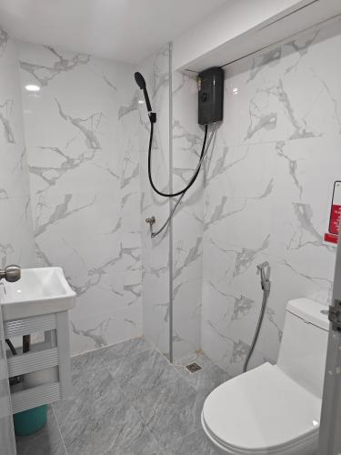 a bathroom with a shower with a toilet and a sink at Shwe Ooe Lay Guest House in Bangkok