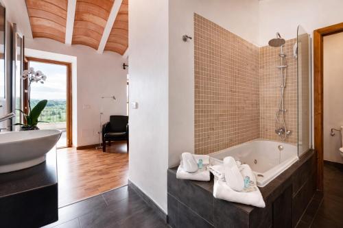 ein Badezimmer mit Badewanne und Waschbecken in der Unterkunft Hotel Can Riera by CheelHotels in Moscari