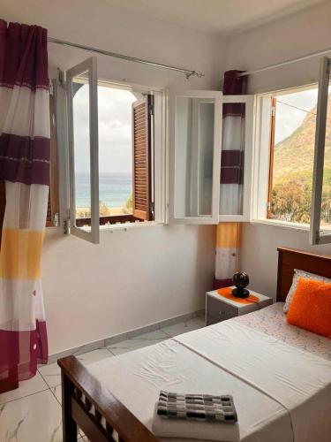 a bedroom with a bed and a view of the ocean at Casa Silvina Tarrafal in Tarrafal