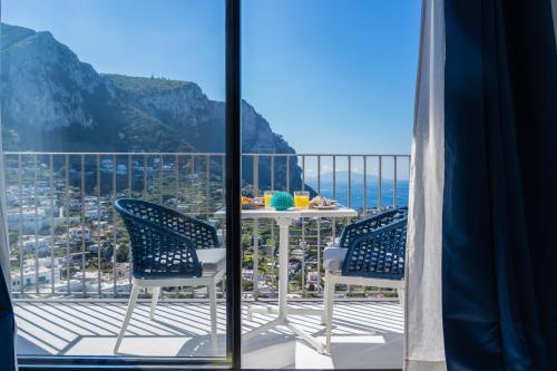 Ein Tisch und Stühle auf einem Balkon mit Aussicht in der Unterkunft Domus Capri in Capri