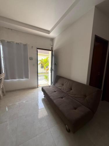 a couch in a living room with a window at Casa de praia PB in Pitimbu