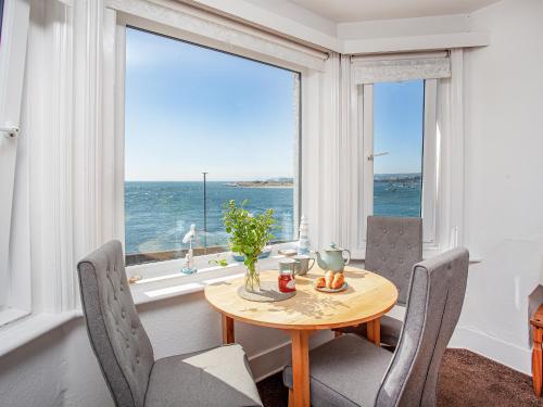 a dining room with a table and chairs and a large window at Mamhead View in Exmouth