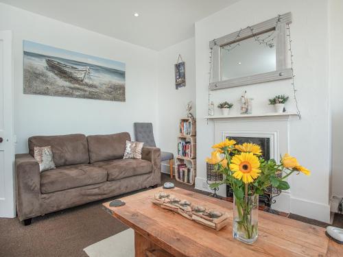 a living room with a couch and a vase of flowers on a table at Mamhead View in Exmouth