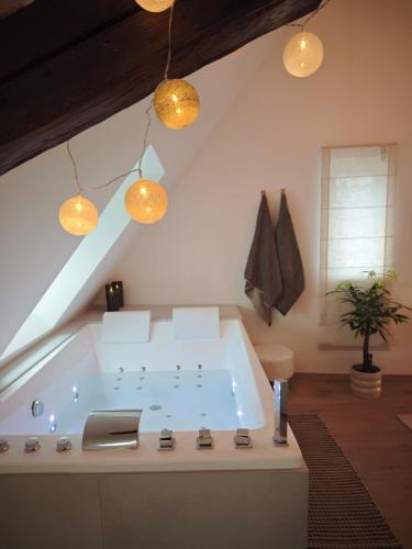 a large bath tub in a room with lights at Slow Suite & Spa Erstein in Erstein
