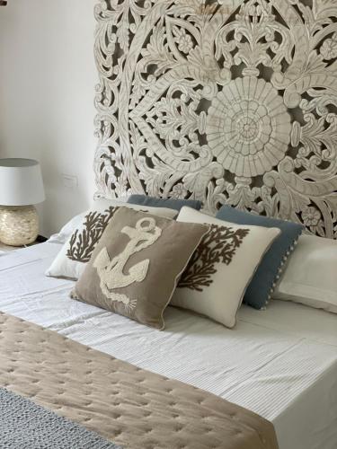 a bed with a headboard and pillows on it at Casa Mare Sabaudia in Sabaudia