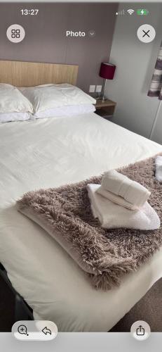 a white bed with two pillows on it at Trailer by the sea in Millom