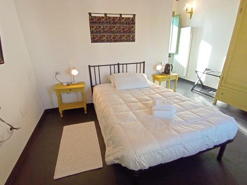 a large bed in a room with two tables at La Casa Vecchia in Nuraminis