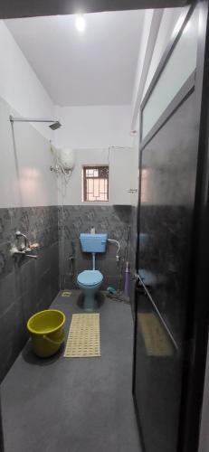 a bathroom with a blue toilet and a tub at Daji Dhabolkar house in Mandrem