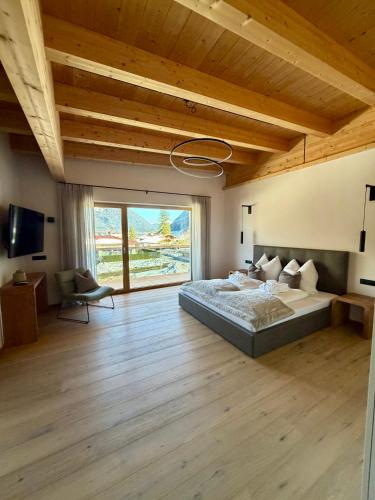 a bedroom with a large bed and a large window at MALIA - Alpine Hideaway in Pertisau