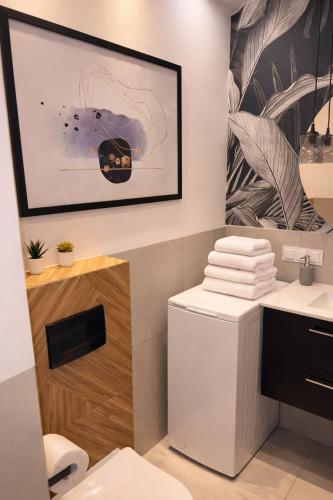 a bathroom with a toilet and a picture on the wall at PIASKI 4 - Boutique stay in Gdańsk