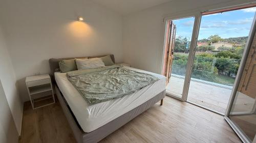a bed in a room with a large window at Casa Paradiso La Cinta San Teodoro in San Teodoro