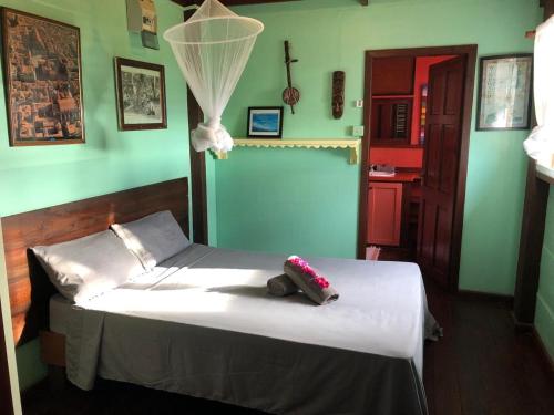a bedroom with a bed with white sheets and green walls at Italian Guesthouse in Gros Islet