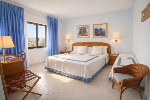 ein Schlafzimmer mit einem Bett, einem Schreibtisch und einem Stuhl in der Unterkunft Hotel Del Levante in Torre Canne