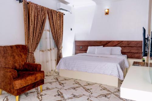 a bedroom with a bed and a chair at Crystal Bricks Apartments in Port Harcourt