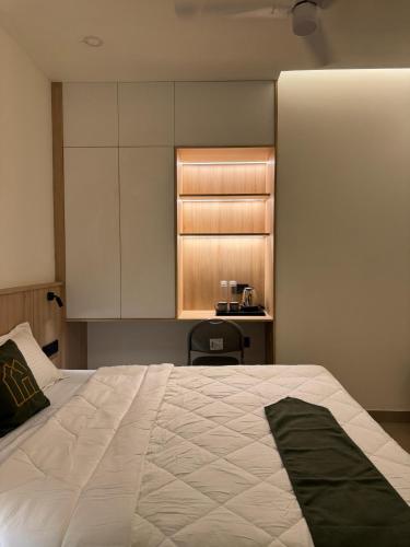 a bedroom with a large white bed and a kitchen at The Zen Retreat in Kozhikode