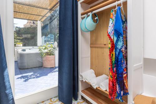 a room with a window with blue curtains at YourHome - Villa Allegria in Positano
