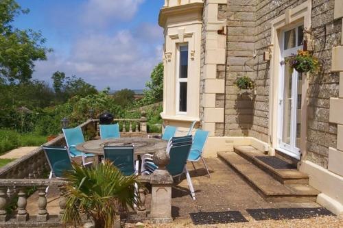 a patio with chairs and a table in front of a house at Clevelands Country House in Wroxall