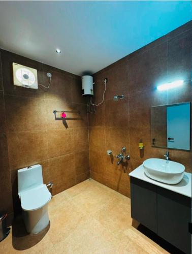 a bathroom with a white toilet and a sink at Mannat Hotel in Tezpur