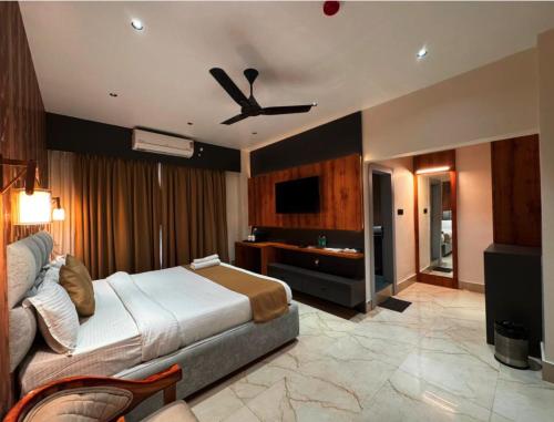 a bedroom with a bed and a ceiling fan at Mannat Hotel in Tezpur
