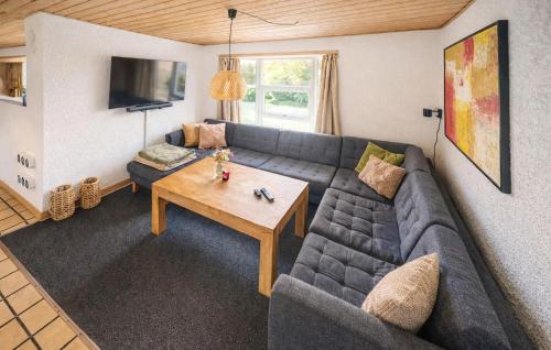 a living room with a couch and a table at Nice Home In Oksbøl With Sauna in Oksbøl