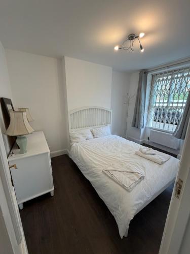 a bedroom with a white bed and a window at Central London 2 bedroom apartment by the river thames in Victoria zone 1 in London