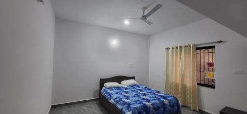 a bedroom with a bed and a ceiling fan at Daji Dhabolkar house in Mandrem