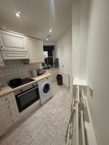 a kitchen with a stove and a washing machine at Central London 2 bedroom apartment by the river thames in Victoria zone 1 in London