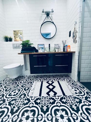 a bathroom with a black and white tile floor at SeaView Apartament in Gdańsk Letnica