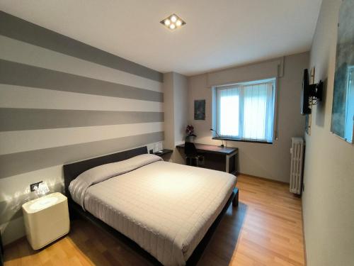 a bedroom with a bed and a striped wall at Casa Dina in Baveno