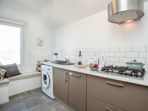 a kitchen with a stove and a washing machine at Mamhead View in Exmouth