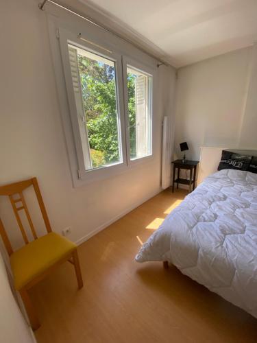 a bedroom with a bed and a chair and two windows at Maison luxueuse proche de Paris centre in Aulnay-sous-Bois
