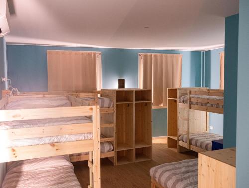 a room with three bunk beds and blue walls at Ostello Casa Peroni in Castelnuovo Bocca dʼAdda