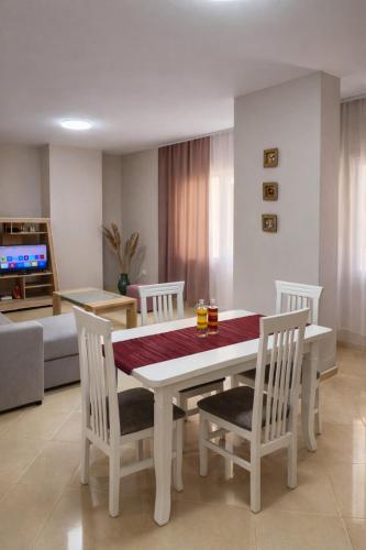 a dining room with a white table and chairs at Dahlila's Home near Lake Ohrid in Pogradec