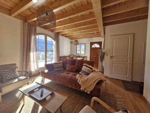 a living room with a couch and a table at Les hauts de LOUVIE in Louvie-Soubiron