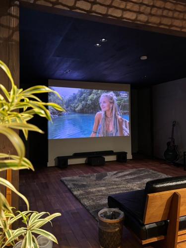 a large screen television with a woman on it at いとしま風遊 in Itoshima