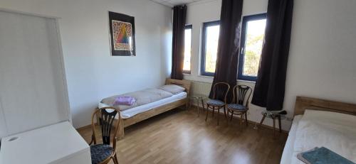 a small room with a bed and two chairs at Monteur und Messewohnung in Rodgau