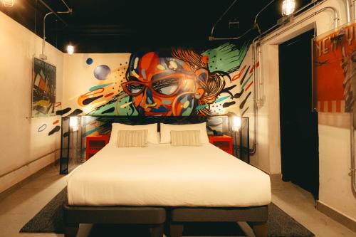 a bedroom with a bed with a painting on the wall at LOFT Hotel by Sommelier Hoteles in Santiago