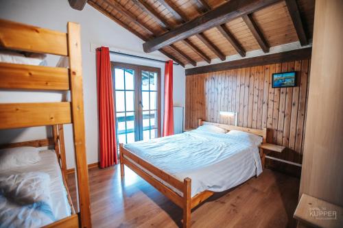 a bedroom with a bed and a bunk bed at Le Grand Cerf 25 pers, Malmedy- Chalet rustique, jardin in Malmedy
