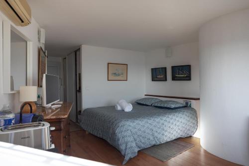 a bedroom with a bed and a desk in it at Meublé La Sergerie in Le Lavandou
