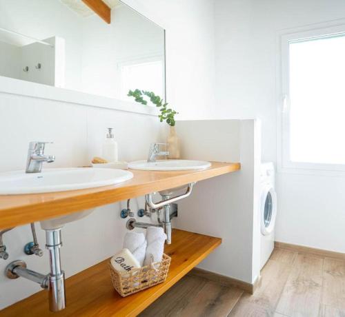 a bathroom with two sinks and a washing machine at Villa Audrey in Cala en Bosc