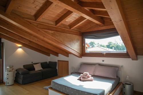 a bedroom with a bed and a couch and a window at Relax house Baveno in Baveno