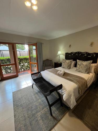 a large bedroom with a large bed and a chair at Del Roza Guest House in Middelburg