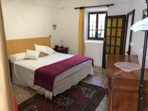 a bedroom with a bed and a table and a window at Casa dei Nonni in Baveno