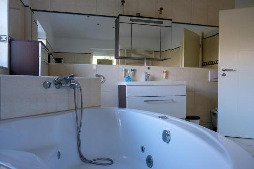 a bathroom with a bath tub with a shower at Villa Vinko in Donje Raštane